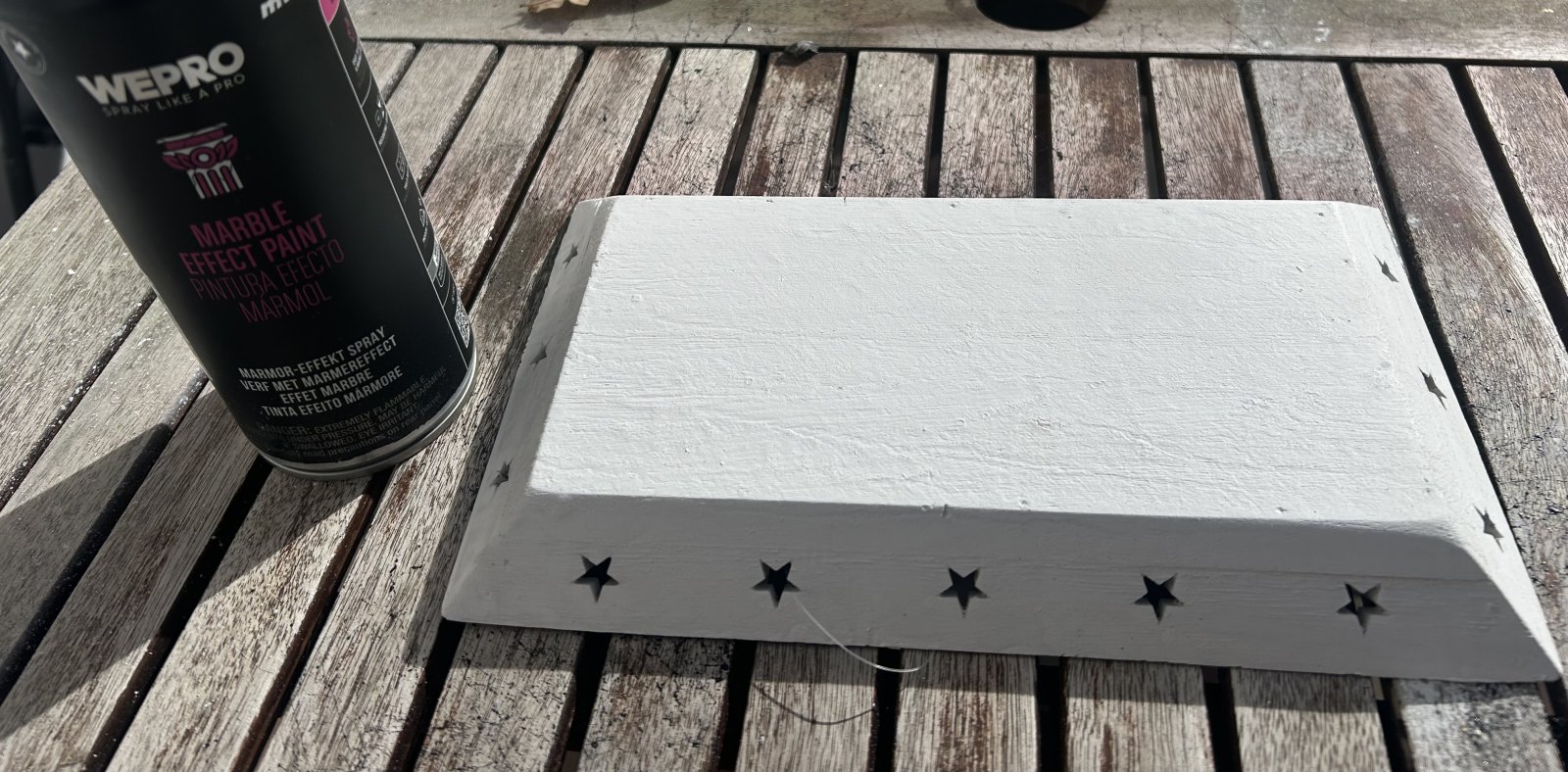 Fehér, csillagokkal díszített fadekoráció fújás előtt és a WEPRO Márványhatás spray